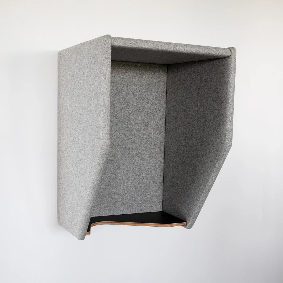 Grey acoustic phone hood mounted on a white wall