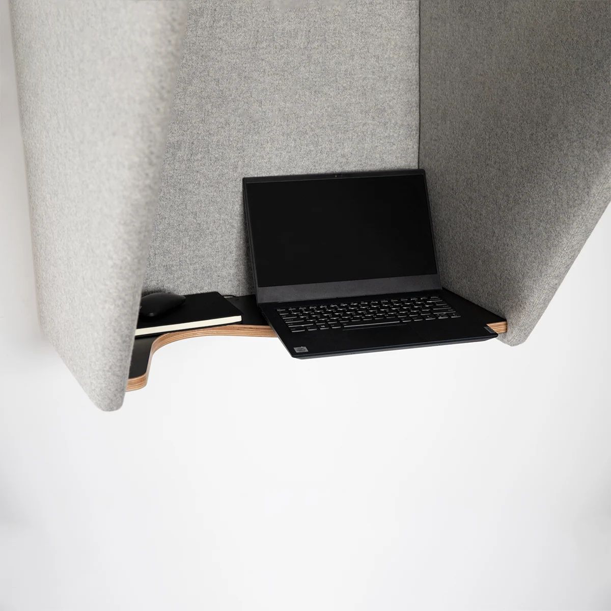 Laptop resting on the integrated shelf inside a grey acoustic phone hood