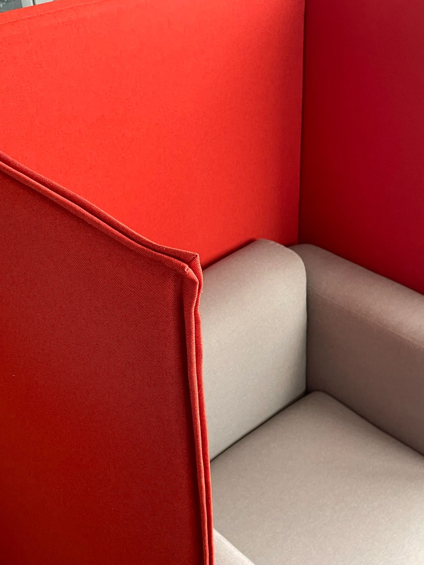 Detail of the interior junction between red privacy panels and a light seat