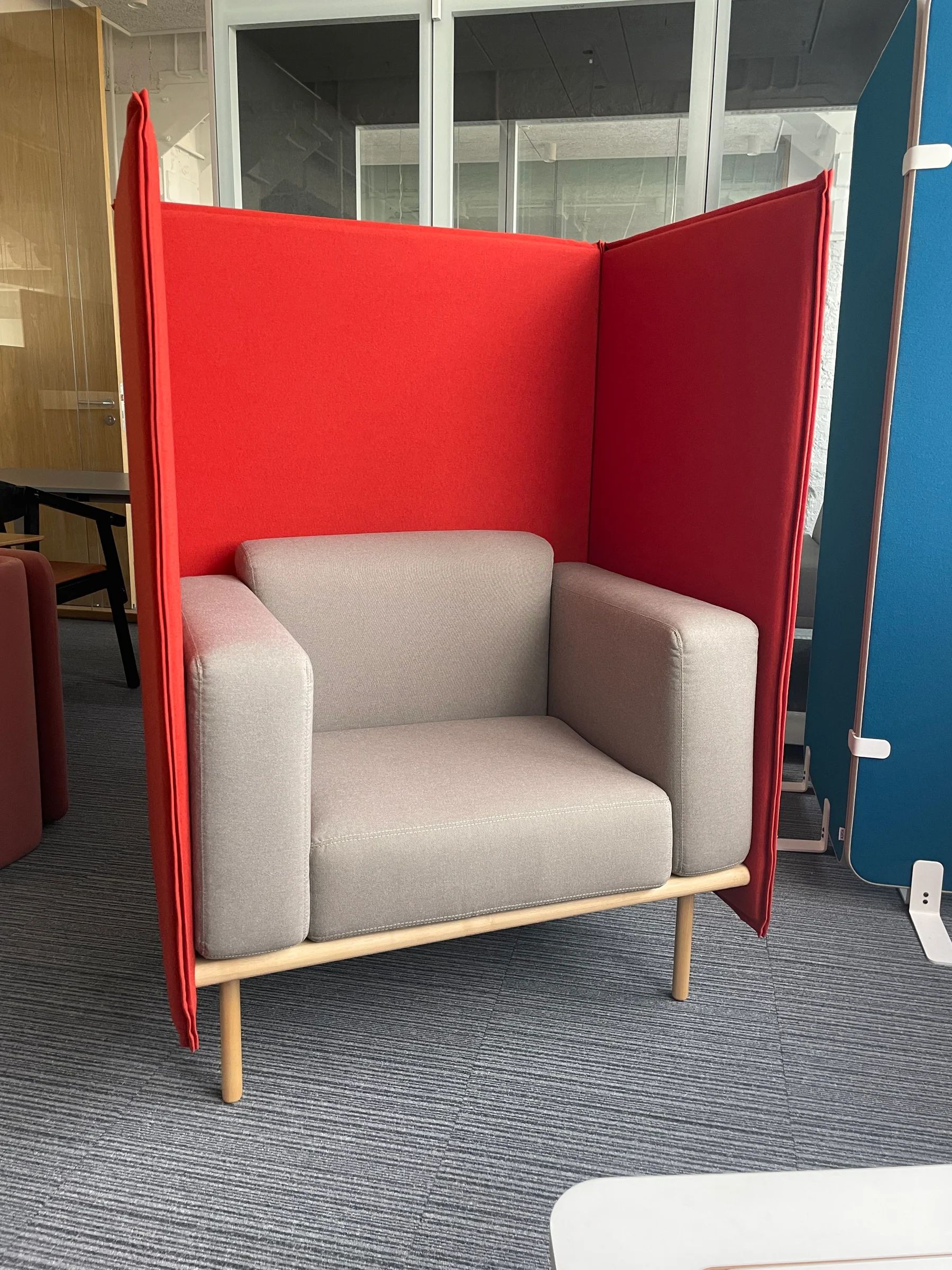 Red high-back modular lounge chair installed in an office