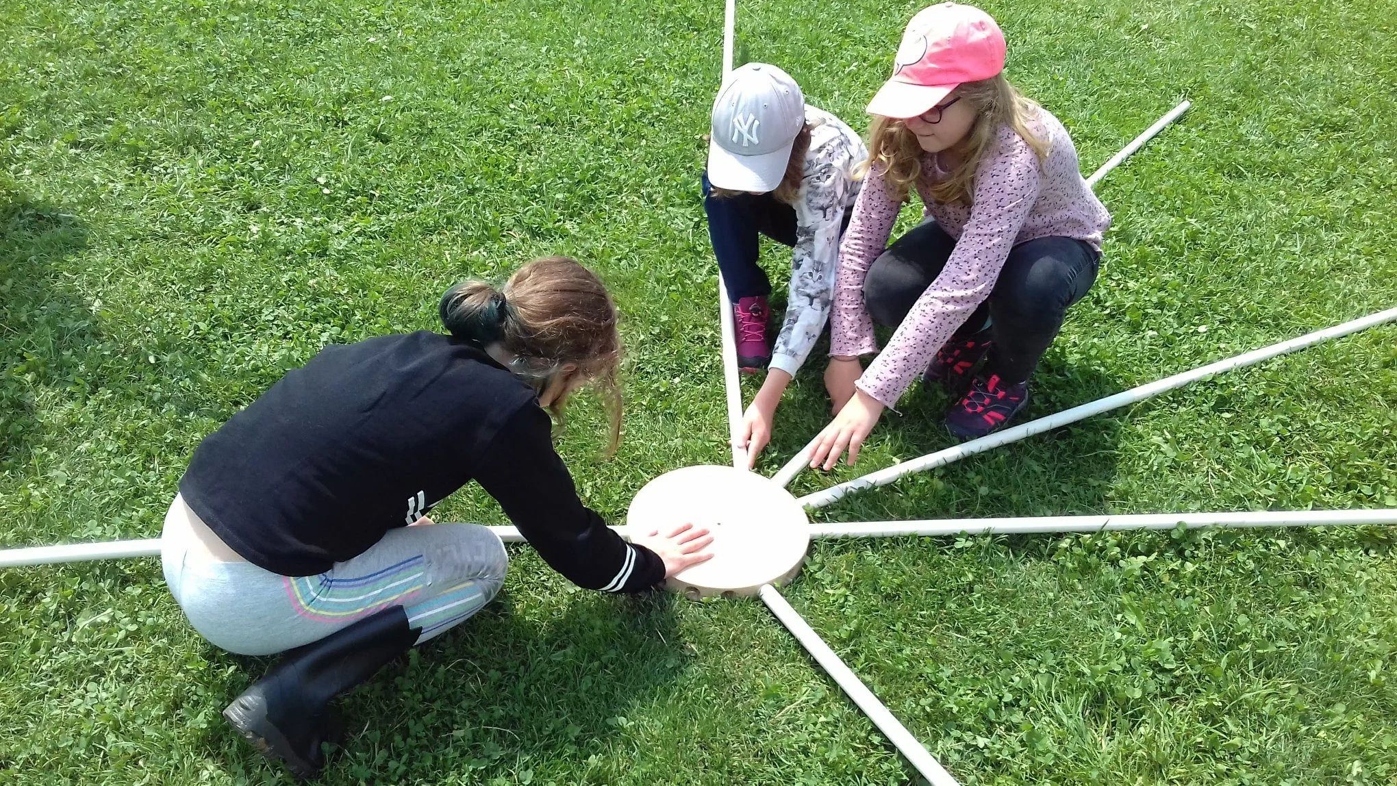 Participants fitting structural beams into the umbrella dome hub