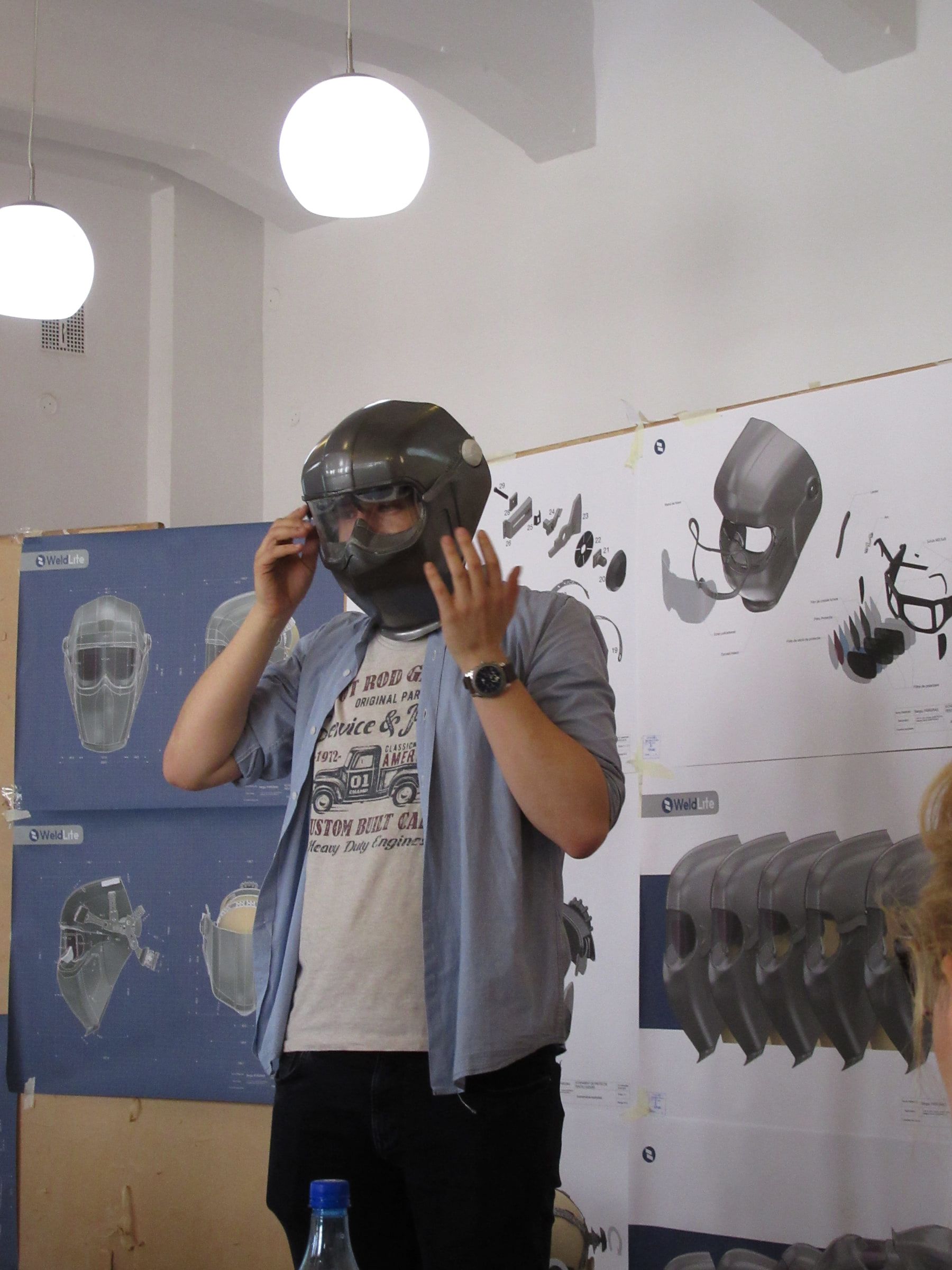Sergiu Părgras presenting and wearing the physical WeldLite prototype beside the development boards